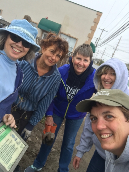 A group of smiling women proudly holds a plaque